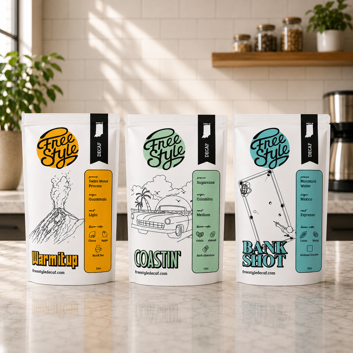 Three stand-up pouches of Free Style coffee beans arranged on a marble countertop in a bright kitchen setting. The pouches are white with colorful labels in yellow, green, and blue, featuring retro-style illustrations and flavor names: Warmup, Coastin', and Bank Shot.